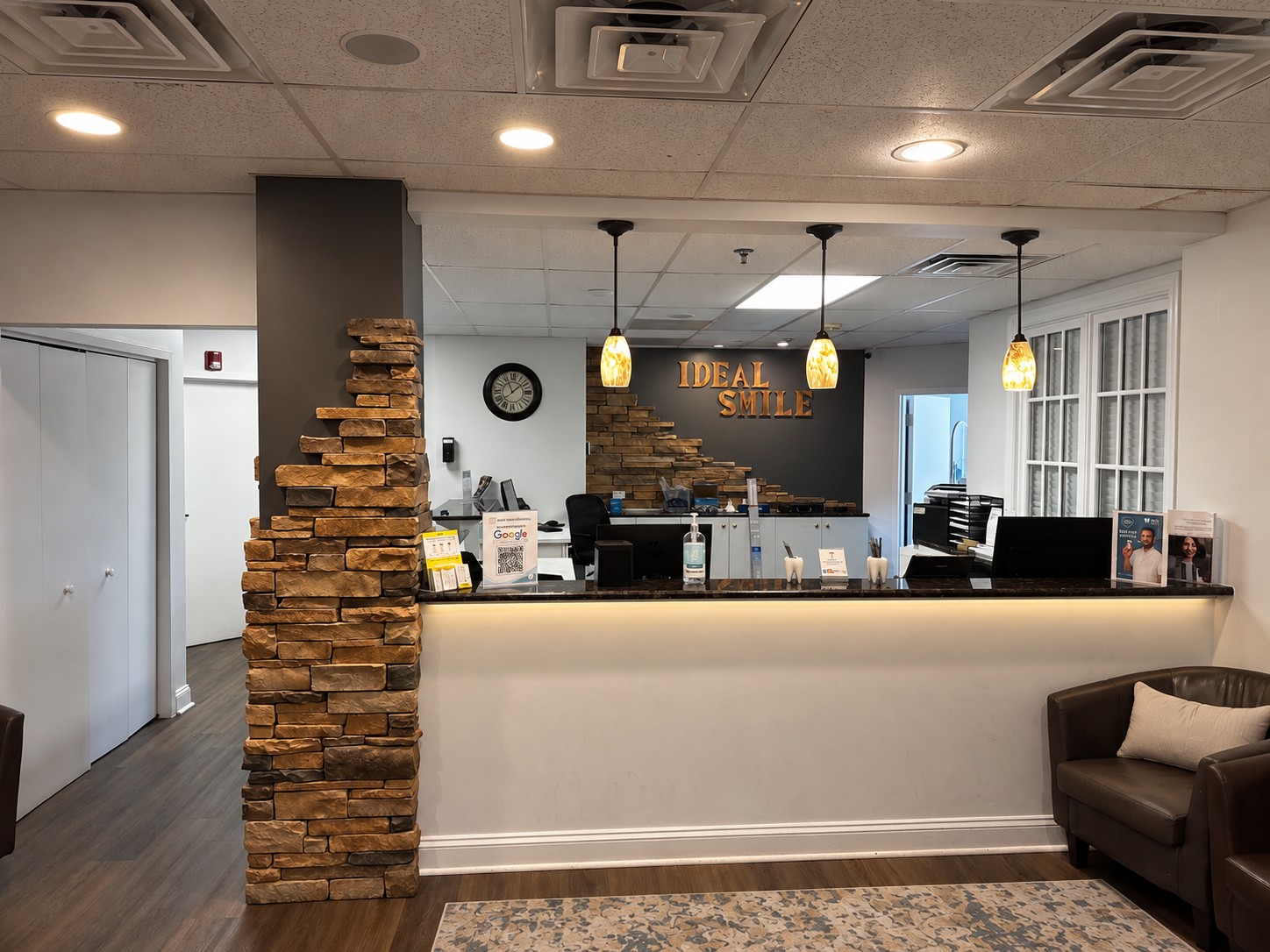 Ideal Smile front desk framed by stone columns and pendant lights